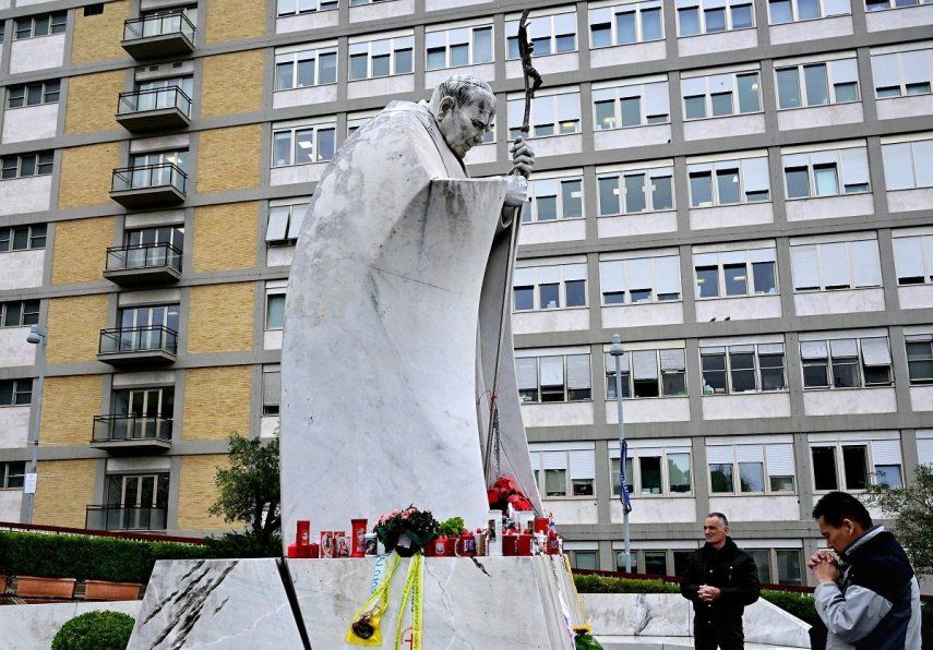 Un hombre reza ante la estatua de Juan Pablo II en el exterior del hospital Gemelli, donde el papa Francisco está internado en Roma, el 25 de febrero de 2025.&nbsp;&nbsp;