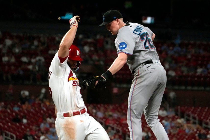 Paul Goldschmidt, de los Cardenales de San Luis, a la izquierda, es puesto Out por el primera base de los Marlins de Miami, Garrett Cooper, para finalizar la octava entrada de un juego de béisbol el lunes 17 de julio de 2023 en San Luis