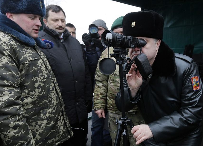 El presidente de Ucrania, Petro Poroshenko (derecha), mira a través de un telescopio en su visita a guardas fronterizos en Kiev, Ucrania, el 14 de febrero de 2015.  (AP)