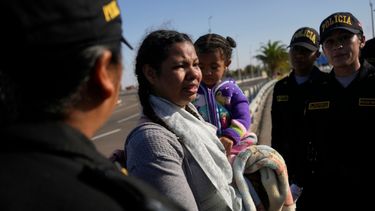 Una migrante venezolana llora cuando la policía la detiene en Tacna, Perú.