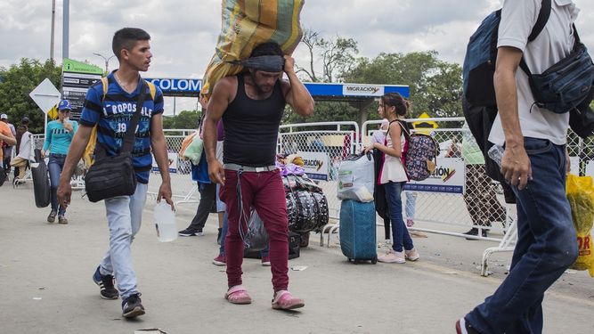 Un hombre carga un gran fardo a la espalda, con una cinta en la frente, mientras trabaja como lomo taxista, o porteador, en la frontera entre Cúcuta, Colombia, y Venezuela, el viernes 20 de septiembre de 2019. 
