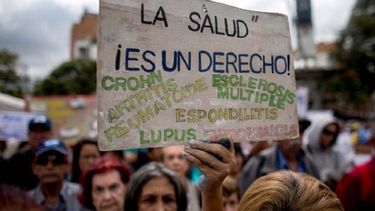 Una mujer muestra un cartel durante una protesta por la escasez de medicinas y tratamientos para la salud en Caracas, Venezuela.