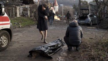 Un hombre llora junto al cuerpo de su esposa muerta durante un ataque ruso, el sábado 31 de diciembre de 2022, en Kiev, Ucrania.