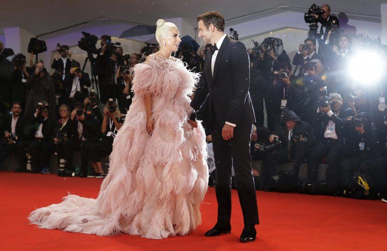 Lady Gaga y Bradley Cooper posan para los fotógrafos al llegar al estreno de A Star Is Born en el Festival de Cine de Venecia de 2018.