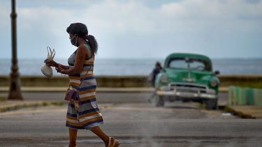 Una mujer que usa mascarilla como medida preventiva contra la pandemia del nuevo coronavirus COVID-19 camina en La Habana, el 20 de octubre de 2020.&nbsp;