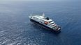 Esta fotografía aérea muestra una vista general del crucero MV Hondius anclado frente al puerto de Praia, la capital de Cabo Verde, el 4 de mayo de 2026. Se han implementado estrictas medidas de precaución, incluyendo el aislamiento, en el crucero anclado frente a las costas de Cabo Verde, donde se sospecha que un brote de hantavirus ha causado la muerte de tres personas, según informó la compañía operadora el 4 de mayo de 2026.
