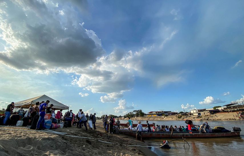 &nbsp;Venezolanos abordan un bote antes de cruzar el río Arauca en Arauca, Colombia, en la frontera con Venezuela, el 22 de enero de 2022.