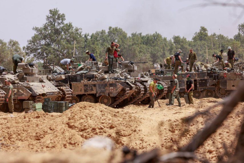Las tropas israelíes trabajan en sus vehículos blindados en una posición cerca de la frontera de Israel con la Franja de Gaza el 18 de mayo de 2025.