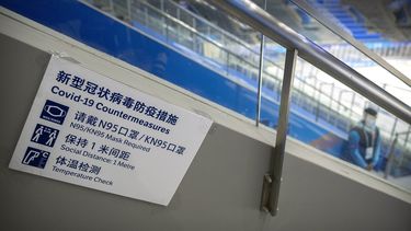En esta imagen de archivo, un miembro del equipo, junto a un cartel con las normas de protección contra el COVID-19, durante la celebración del evento de prueba de hockey sobre hielo previo a los Juegos Olímpicos de Invierno de Beijing 2022, en el Estadio Nacional Indoor, en Beijing, el 10 de noviembre de 2021.&nbsp;