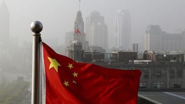 Foto tomada el 14 de abril del 2016 de una bandera china junto a varios edificios en Shanghái. Una serie transmitida por el canal estatal CCTV muestra la corrupción en el gigante asiático.
