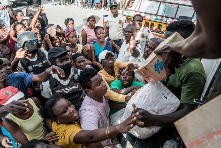 Policías monitorean a la multitud mientras las víctimas del terremoto reciben suministros durante la distribución de alimentos y agua en el cruce de 4 Chemins en Les Cayes, Haití.