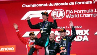 El piloto italiano Kimi Antonelli, ganador de la carrera Mercedes, es levantado por el piloto británico Lewis Hamilton (izquierda) y el técnico compuesto por equipos senior de carreras de Mercedes, Dean Hale, cuando el piloto holandés Max Verstappen, se une a la celebración en el podio al final del Gran Premio de Fórmula 1 de Canadá de 2026