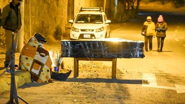 Un ata&uacute;d envuelto en pl&aacute;stico que contiene los restos de Crist&oacute;bal Huanca Mendoza yace afuera de un cementerio durante un velorio improvisado por sus amigos en la calle mientras esperan para enterrarlo en una fosa com&uacute;n en Cochabamba, Bolivia, el mi&eacute;rcoles 1 de julio de 2020. Los servicios funerarios de Cochabamba est&aacute;n al borde del colapso con cad&aacute;veres que se acumulan para ser incinerados o enterrados en medio de un aumento en los casos del nuevo coronavirus.&nbsp;