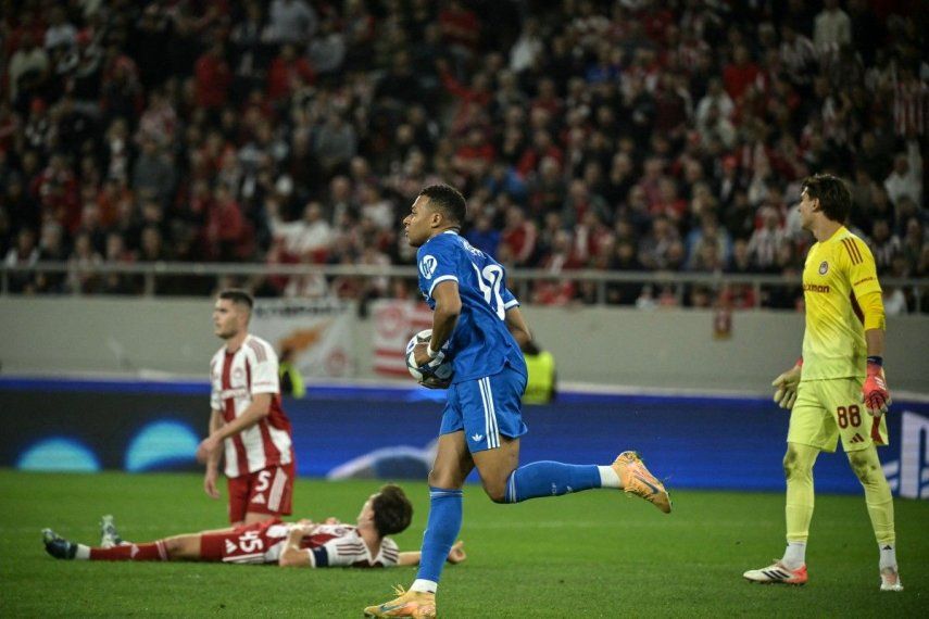 El delantero francés del Real Madrid, Kylian Mbappé, agarra el balón tras marcar el primer gol de su equipo durante la quinta jornada de la fase de liga de la UEFA Champions League, partido entre el Olympiakos (GRE) y el Real Madrid (ESP) en el estadio Georgios Karaiskakis de El Pireo el 26 de noviembre de 2025.