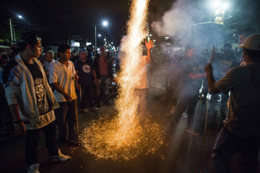 Un hombre lanza un cohete en la celebración de la ventaja del partido de Gobierno en elecciones municipales.
