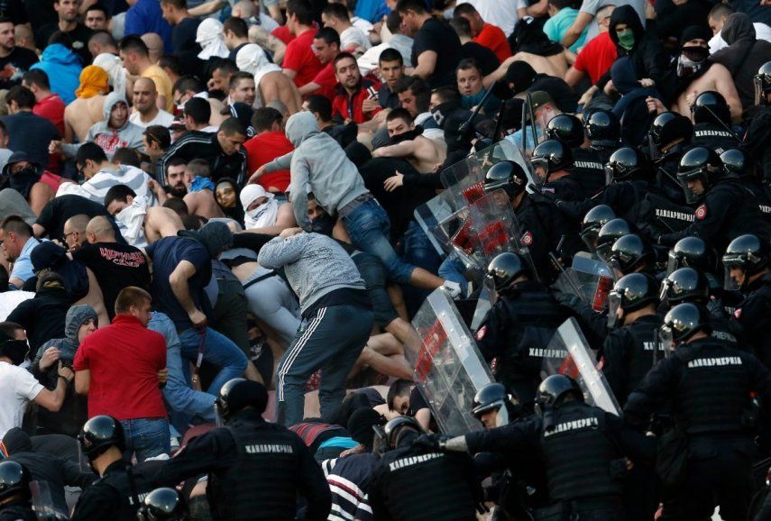 En esta foto del 16 de abril de 2016, policías antimotines chocan con hinchas del Estrella Roja durante un partido de la Liga Serbia ante el Partizan en Belgrado.