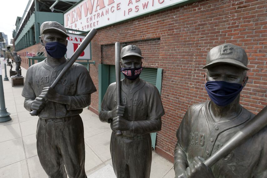 La foto del 17 de abril de 2020 muestra, de izquierda a derecha, las estatuas de Ted Williams, Bobby Doerr y Johnny Pesky, con mascarillas, frente al Fenway Park de Boston&nbsp;