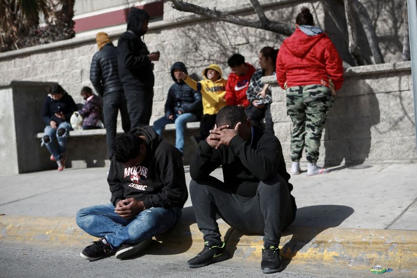Migrantes afligidos al frente del centro de detención de migrantes mexicano en Ciudad Juárez, México, en el que un incendio en un dormitorio dejó más de tres docenas de migrantes muertos.