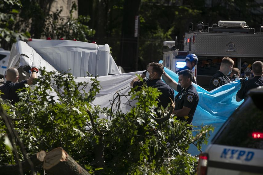 Polic&iacute;as de la ciudad de Nueva York tapan de la vista a una persona que muri&oacute; despu&eacute;s de que un &aacute;rbol cayera sobre una camioneta cuando la tormenta tropical Isa&iacute;as atravesaba Nueva York, el martes 4 de agosto de 2020 en Nueva York