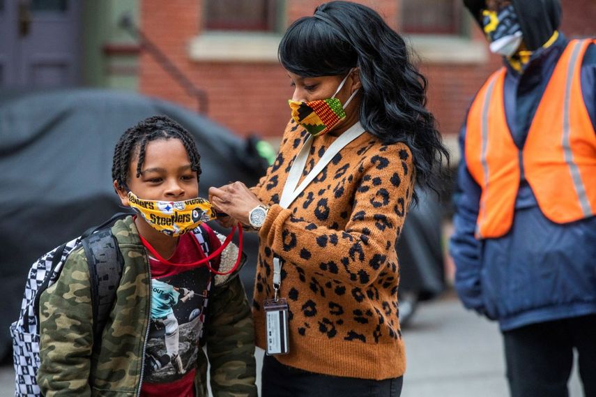 Jenea Edwards, de North Side, ayuda a su hijo Elijah, de nueve años y estudiante de tercer grado de primaria, a colocarse la mascarilla antes de ingresar a la escuela privada.