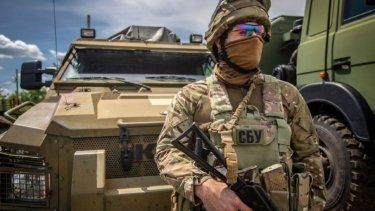 Un soldado ucraniano frente a un vehículo blindado.