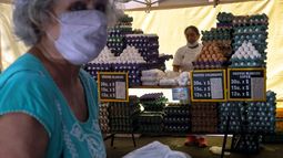 Inflación, una mujer se aleja después de comprar huevos en un mercado en Buenos Aires, Argentina.