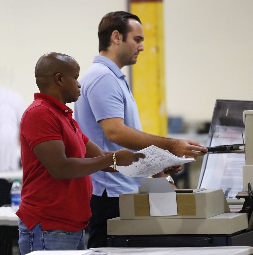 Empleados de la autoridad de Elecciones de Palm Beach recuentan votos en 2016.
