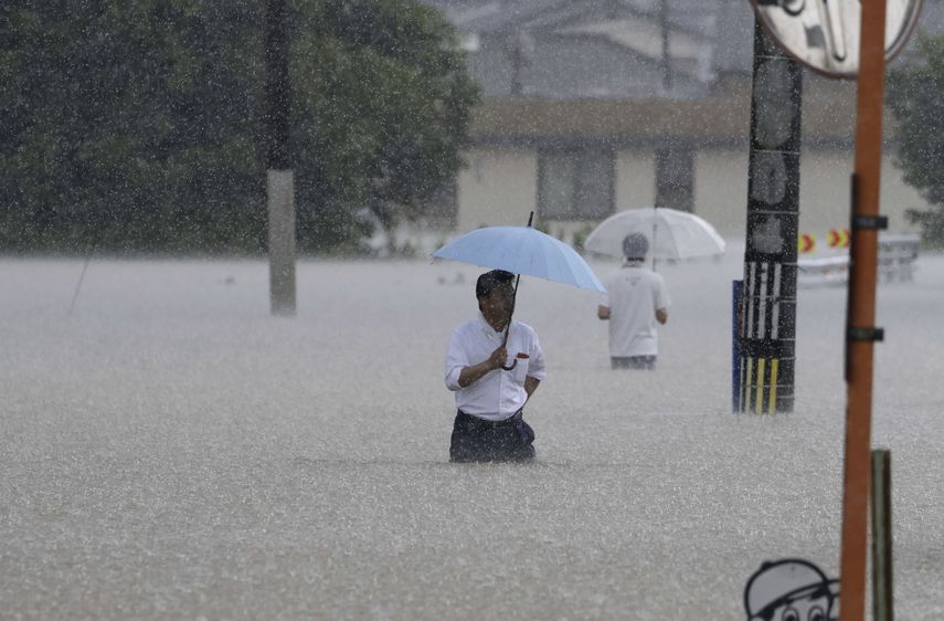 Personas caminan en una calle inundada por las fuertes lluvias, el lunes 10 de julio de 2023, en Kurume, en la prefectura de Fukuoka, en el sur de Japón.&nbsp;