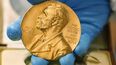 En esta imagen de archivo, tomada el 17 de abril de 2015, un empleado de la biblioteca nacional muestra una medalla de oro del Premio Nobel.&nbsp;