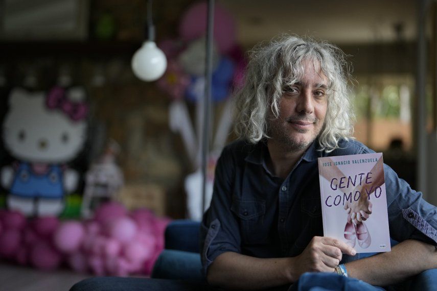 El escritor José Ignacio Valenzuela posa con su más reciente libro Gente como yo el jueves 6 de abril de 2023, en la casa donde vive con su pareja y su hija en Palmetto Bay, Florida.
