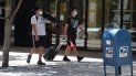 Dos jóvenes caminan por una calle de Miami, mientras se protegen del coronavirus. Dos jóvenes caminan por una calle de Miami, mientras se protegen del coronavirus.