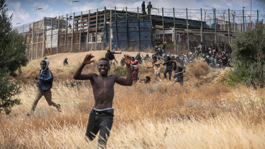 Migrantes emprenden la carrera en suelo español después de cruzar las vallas que separan el enclave español de Melilla, del territorio de Maruecos, el viernes 24 de junio de 2022.&nbsp;