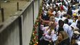 Personas colocan rosas en lo que queda en pie del Muro de Berl&iacute;n durante una ceremonia para conmemorar el 30 aniversario de la ca&iacute;da del muro en el memorial en Bernauer Strasse en Berl&iacute;n, el s&aacute;bado 9 de noviembre de 2019.&nbsp;