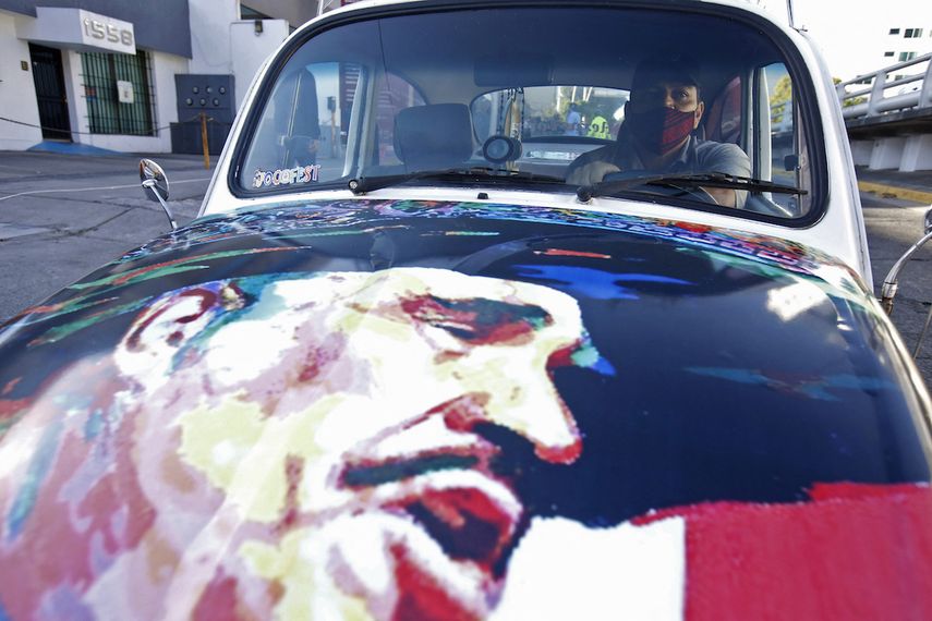 Un fan de Vicente Fernández le rinde tributo pintando el rostro del cantante en su carro, que estacionó afuera del hospital en Guadalajara donde falleció el astro de la música regional mexicana.