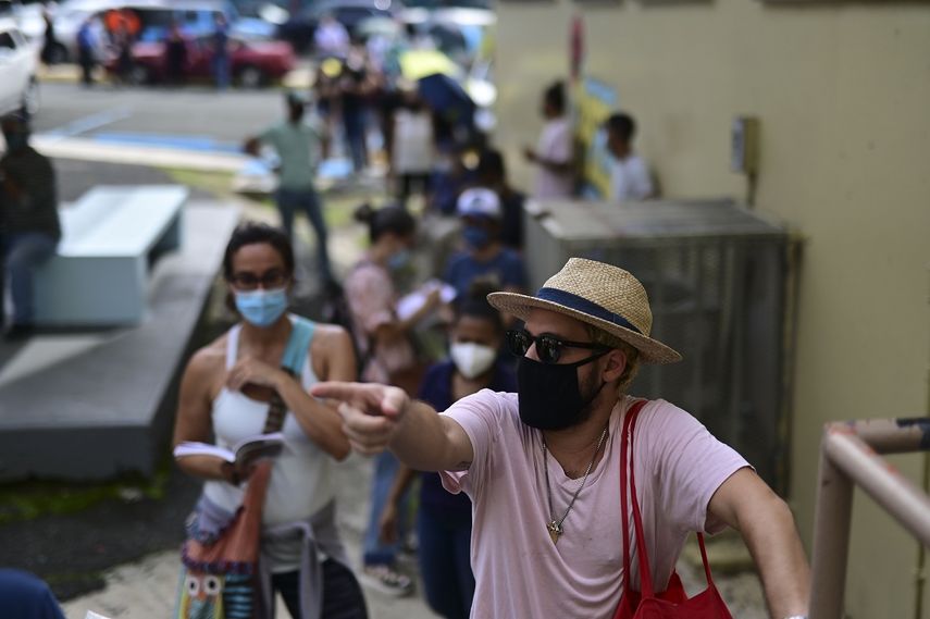 Votantes, con mascarilla por la pandemia del coronavirus, esperan en fila para depositar sus boletas en las elecciones generales, en un centro de votación habilitado en la escuela Rafael Labra, en San Juan, Puerto Rico, el 3 de noviembre de 2020.&nbsp;