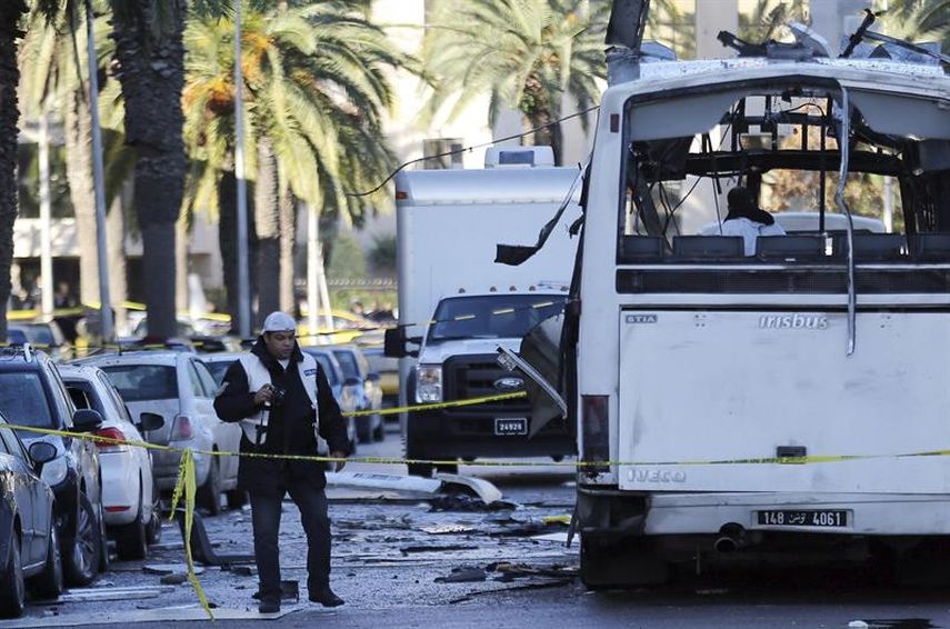 Policías forenses inspeccionan los restos de un autobús tras el atentado contra varios guardias presidenciales que se encontraban a bordo del vehículo, en Túnez.(EFE)