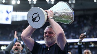El entrenador greco-australiano del Tottenham Hotspur, Ange Postecoglou, sostiene en alto el trofeo de la Europa League, tras su victoria a mitad de semana en la final de la Europa League el 21 de mayo, mientras él y el equipo lo muestran a los aficionados tras el partido de la Premier League inglesa entre el Tottenham Hotspur y el Brighton and Hove Albion en el Tottenham Hotspur Stadium en Londres, el 25 de mayo de 2025. El Tottenham Hotspur despidió al técnico Ange Postecoglou el 6 de junio, apenas dos semanas después de que el australiano ganara la Europa League para poner fin a la sequía de 17 años de trofeos del club.