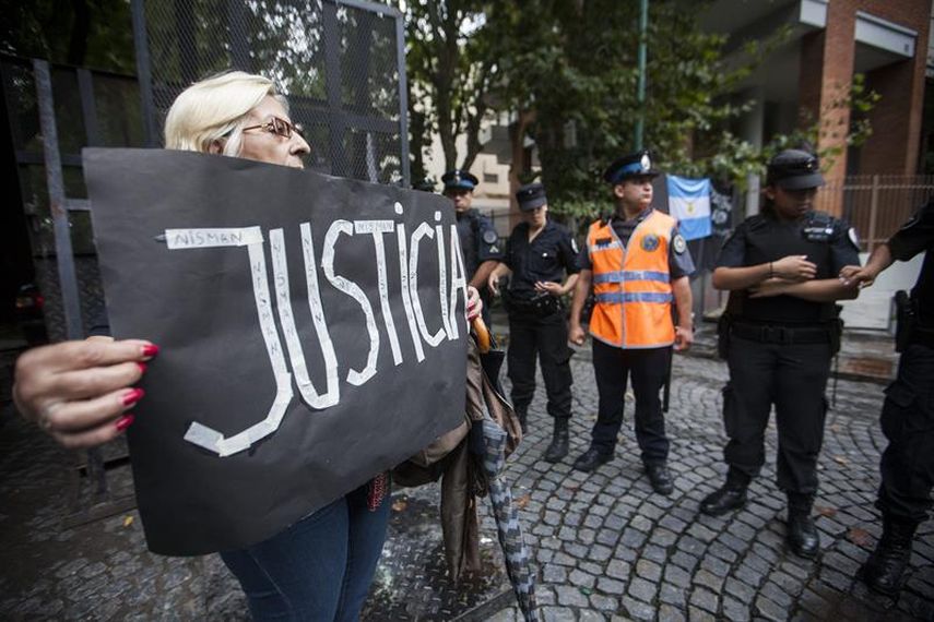 Policías argentinos vigilan los alrededores del sitio donde se realiza el velatorio del del Fiscal Alberto Nisman, mientras manifestantes protestan pidiendo justicia. (EFE) 