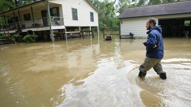 Clayton Lobue camina entre las aguas mientras se dirige a su casa, el viernes 3 de mayo de 2024, en New Caney, Texas.