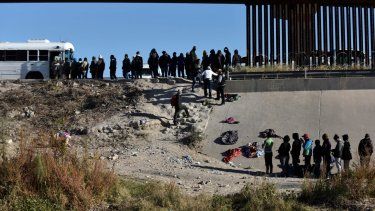 Migrantes aguardan para abordar un autobús del gobierno estadounidense después de cruzar la frontera, el lunes 12 de diciembre de 2022, desde Ciudad Juárez, México, hacia El Paso, Texas.&nbsp;