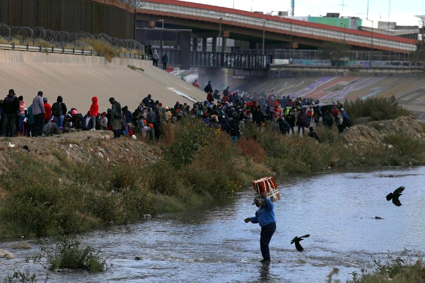Migrantes cruzan el Río Grande para entregarse a los agentes de la Patrulla Fronteriza de EEUU en El Paso, Texas, visto desde Ciudad Juárez, estado de Chihuahua, México.