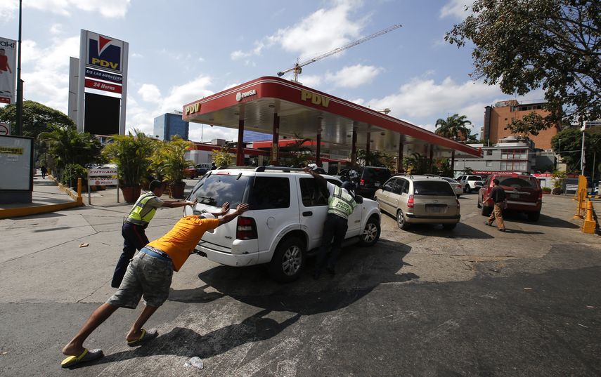 Unas personas empujan un autom&oacute;vil que se qued&oacute; sin combustible en una de las pocas gasolineras que tiene un generador el&eacute;ctrico durante un apag&oacute;n en Caracas, el domingo 10 de marzo de 2019.&nbsp;