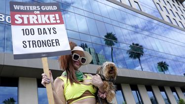 Phoebe Price lleva a su perro Arnold junto con un cartel en una protesta frente a los estudios de Netflix el miércoles 9 de agosto de 2023 en Los Ángeles. La huelga de guionistas de Hollywood alcanzó la marca de los 100 días, las industrias del cine y la televisión de Estados Unidos siguen paralizadas por huelgas de guionistas y actores.