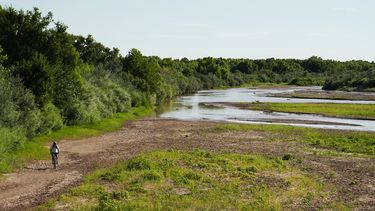 Un ciclista recorre en bicicleta un lecho mayoritariamente seco en un tramo del Rio Grande en Albuquerque, Nuevo México, el 27 de julio de 2022.&nbsp;