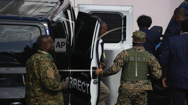 Agentes bahamenses trasladan a prisión a Sam Bankman-Fried.