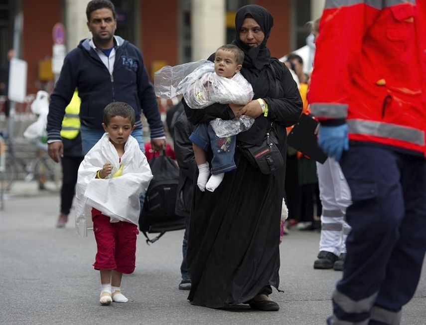 Un niño refugado camina junto a su familia antes de ser conducidos a un centro de acogida a su llegada a la estación ferroviaria de Múnich, Alemania, donde se espera que más de 10.000 refugiados lleguen tras su larga marcha a través de los Balcanes has