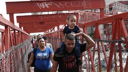 Migrantes cubanos son escoltados por las autoridades migratorias mexicanas en Ciudad Juárez, mientras cruzan el puente internacional Paso del Norte para ser procesados como solicitantes de asilo en el lado estadounidense de la frontera.