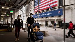 Una familia con cubrebocas pasa frente a la Bolsa de Valores de Nueva York.&nbsp;