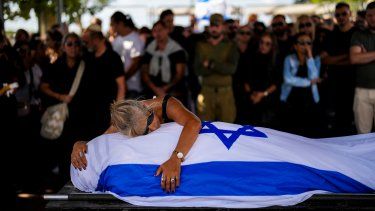 La madre de Antonio Macías llora sobre el cadáver de su hijo, cubierto con la bandera de Israel, en el cementerio Pardes Haim, en Kfar Saba, cerca de Tel Aviv, Israel, el 15 de octubre de 2023. Macias fue asesinado por insurgentes de Hamás cuando asistía a un festival de música en el sur de Israel a principios de mes.