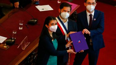 El presidente Gabriel Boric, en el centro, sostiene el borrador final de la nueva constitución que será presentada a los chilenos, junto con los miembros de la Convención Constituyente, María Elisa Quinteros y Gaspar Domínguez.